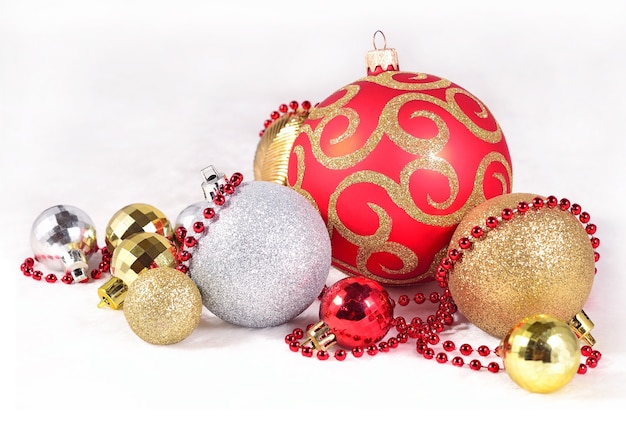 Decorazioni natalizie dorate, argentate e rosse su sfondo bianco