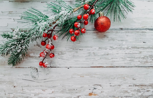 Decorazioni natalizie e confezione regalo su uno sfondo di legno con fiocchi di neve e posto per il testo