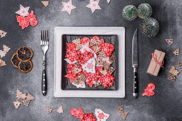 Decorazioni natalizie e pan di zenzero su un tavolo di cemento scuro Prepararsi alla celebrazione