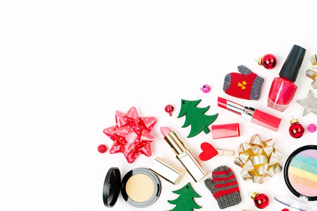 Decorazioni natalizie e prodotti cosmetici su sfondo bianco. Concetto creativo di festa e celebrazione. Disposizione piatta, vista dall'alto