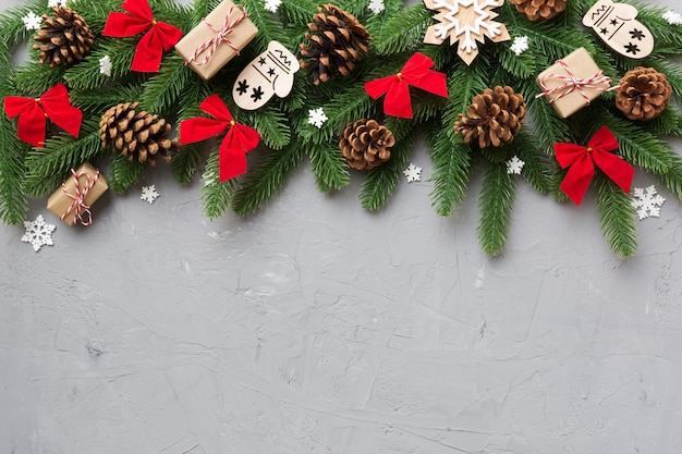 Decorazioni natalizie e ramo di abete e scatola regalo sul tavolo scuro. Cornice vista dall'alto con spazio di copia