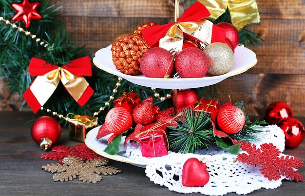 Decorazioni natalizie su alzata da dessert, su tavola di legno