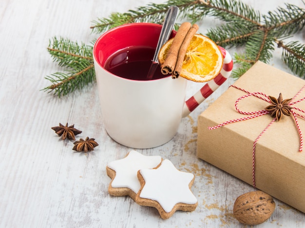 Decorazioni natalizie - una tazza di tè ai frutti di bosco e una confezione regalo.