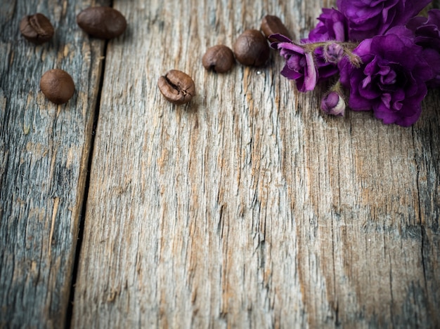 Decorazioni per cuori di carta di San Valentino, violette e caffè al cioccolato su fondo di legno rustico.