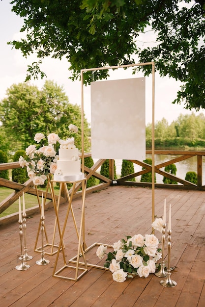 Decorazioni per feste o matrimoni con bellissime composizioni di rose bianche con uno sfondo vuoto e una torta bianca in natura