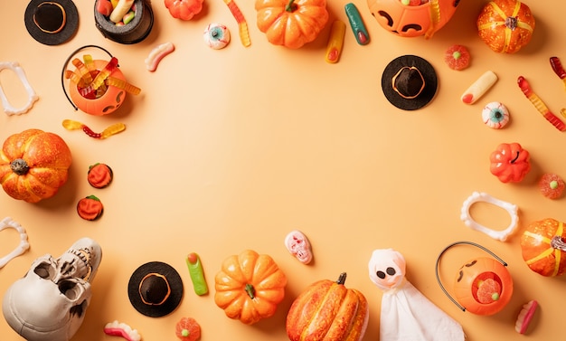 Decorazioni per le feste di Halloween con zucche e caramelle su sfondo arancione