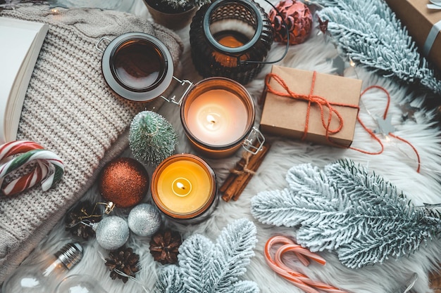 Decorazioni per le vacanze di natale vista dall'alto piatta candele accese giocattoli regalo rami di abete su soffici plaid