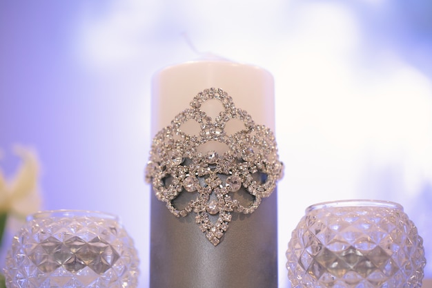 Decorazioni per matrimoni in stile argento con cristalli, pizzi e fiori. Candele nuziali per il focolare familiare