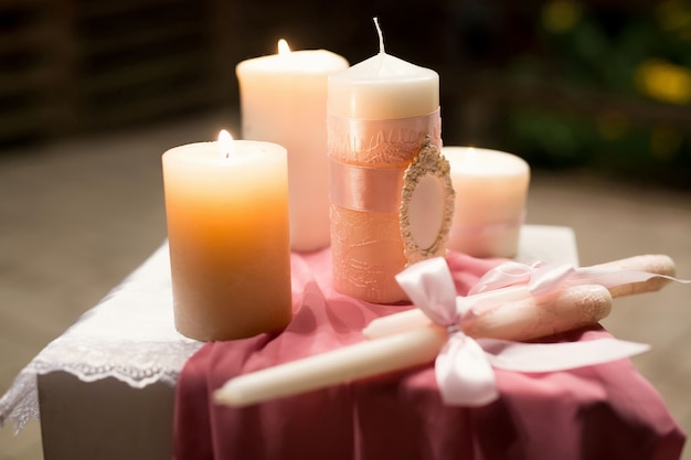 Decorazioni per matrimoni in stile rosa con cristalli, pizzi, fiori e iniziali. Candele nuziali per il focolare familiare