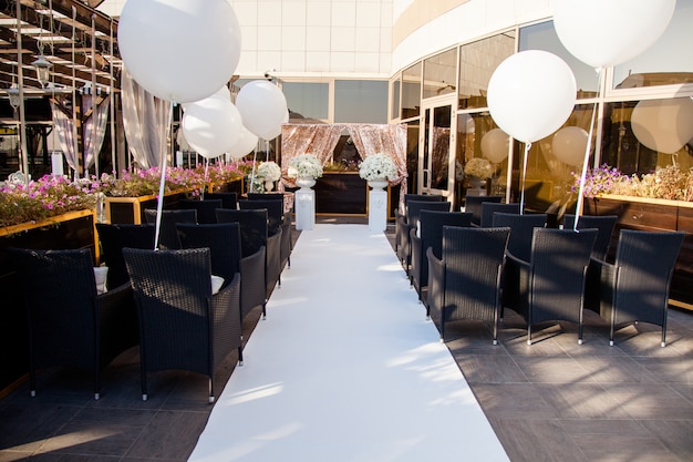 Decorazioni per matrimoni, sedie per ospiti, fedi nuziali e enormi palloncini bianchi