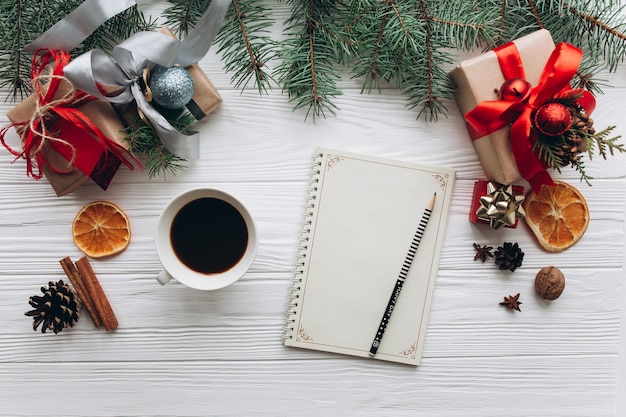 Decorazioni, regali e cibo di Natale su un fondo di legno bianco.