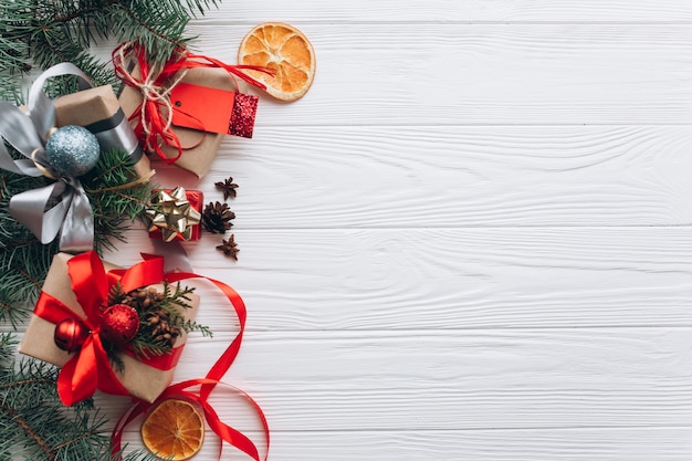 Decorazioni, regali e cibo di Natale su un fondo di legno bianco.