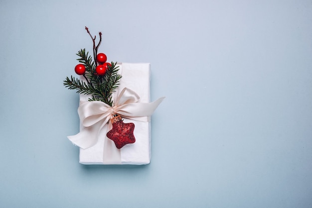 Decorazioni rosse dell'albero di abete del regalo sulla composizione di natale del fondo blu