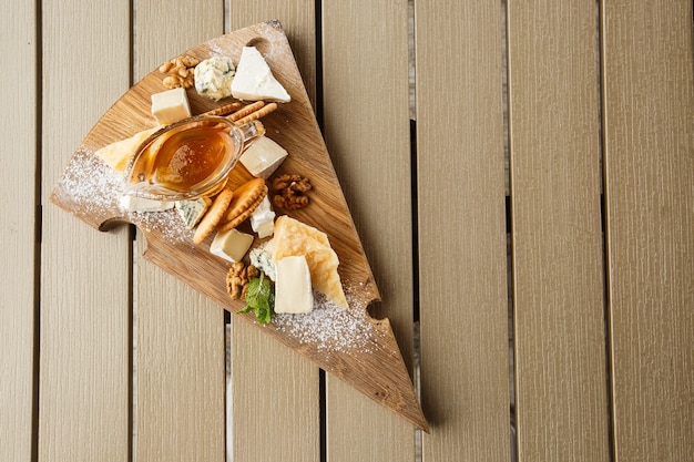 Degustazione del piatto di formaggi su un piatto di legno.