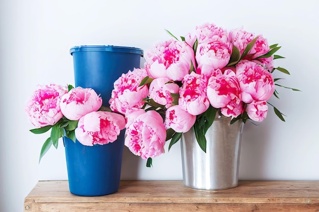 Delicati mazzi rosa di peonie in vasi su tavola di legno