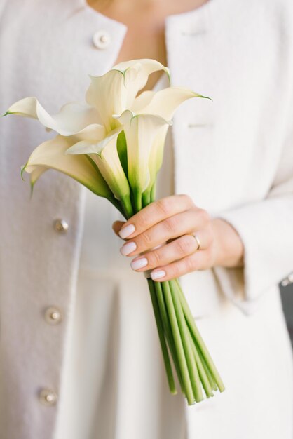 Delicato bouquet bianco di calle nelle mani della sposa al matrimonio