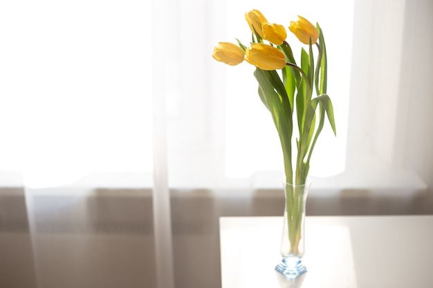 Delicato bouquet di cinque tulipani gialli in vaso di vetro