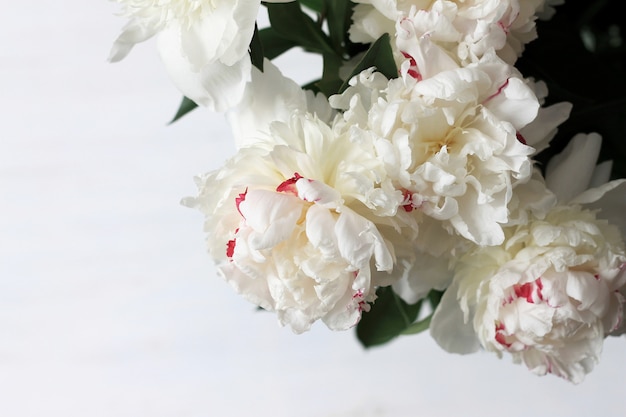 Delicato bouquet di peonie su legno chiaro