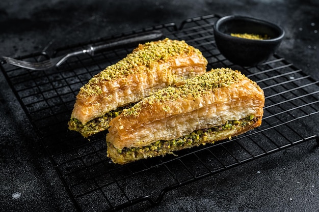 Delizie turche Havuc Dilim Baklava con pistacchio e miele Sfondo nero Vista dall'alto