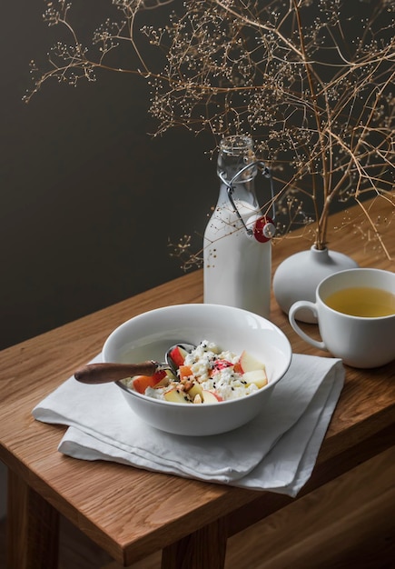 Deliziosa colazione a base di ricotta con noci di miele di mele e tè verde su un tavolo in legno con vista dall'alto