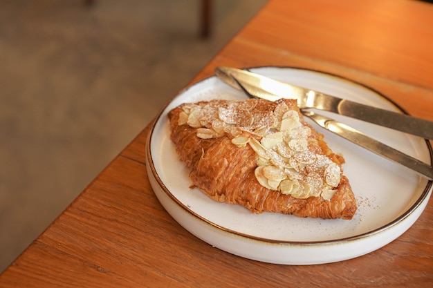 Deliziosa colazione con croissant freschi e caffè servito con burro sulla tavola di legno.