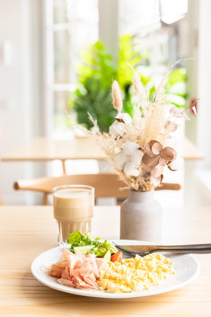 Deliziosa colazione con uova strapazzate Prosciutto di Parma o jamon e insalata di verdure servita con caffè