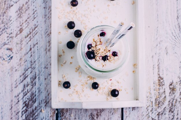 Deliziosa colazione salutare o spuntino. Yogurt con bacche di ribes nero, fiocchi d&#39;avena e menta in vetro