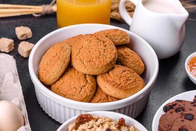 Deliziosa colazione sana nutriente con uova di muesli biscotti d'avena latte e marmellata Mangiare sano all'inizio della giornata