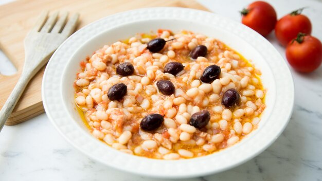 Deliziosa e salutare insalata di fagioli bianchi con merluzzo e olive nere