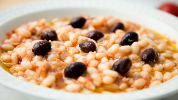 Deliziosa e salutare insalata di fagioli bianchi con merluzzo e olive nere