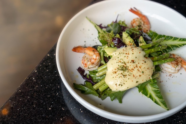 Deliziosa e sana insalata di gamberi gamberetti, asparagi verdi, prezzemolo e verdure in un piatto