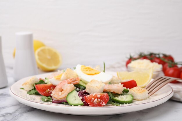 Deliziosa insalata Cesare con gamberetti su un tavolo di marmo bianco