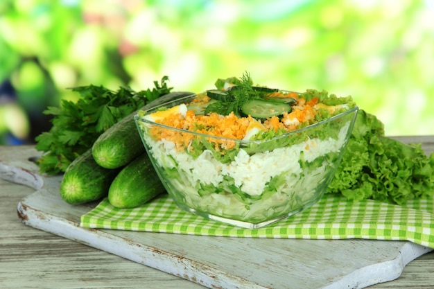 Deliziosa insalata con uova di cavolo e cetrioli sulla tavola di legno