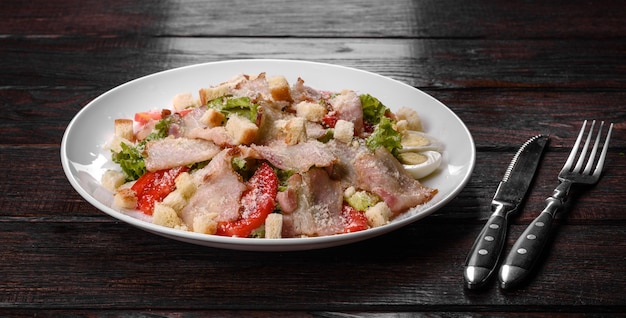 Deliziosa insalata fresca con pancetta e pomodori con spezie e verdure. Preparazione della tavola festiva in famiglia