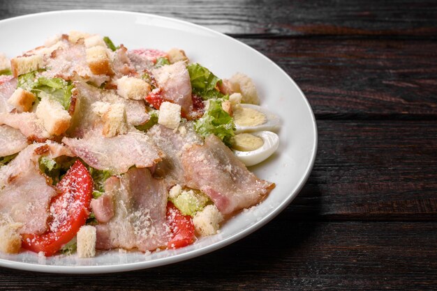 Deliziosa insalata fresca con pancetta e pomodori con spezie e verdure. Preparazione della tavola festiva in famiglia