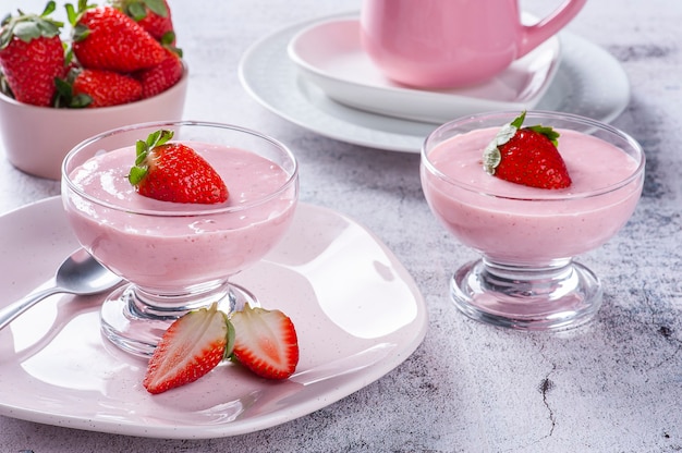 Deliziosa mousse di fragole in una ciotola di vetro con fragole fresche.