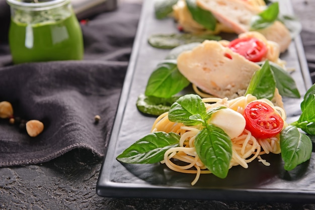 Deliziosa pasta con basilico, pomodori e pane sulla piastra