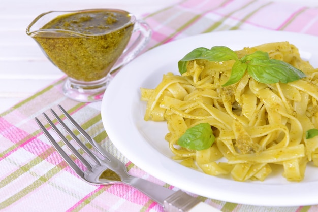 Deliziosa pasta con pesto sul piatto sul primo piano della tavola