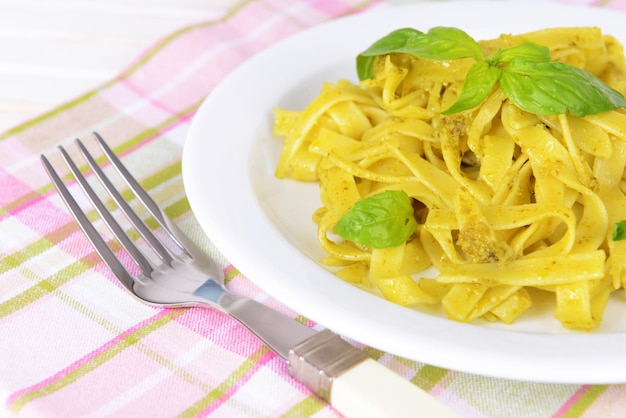 Deliziosa pasta con pesto sul piatto sul primo piano della tavola