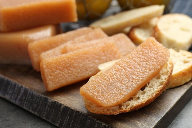 Deliziosa pasta di quince dolce e pane su tavolo grigio da vicino
