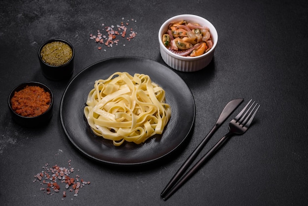 Deliziosa pasta fresca con pesto e frutti di mare su un piatto nero