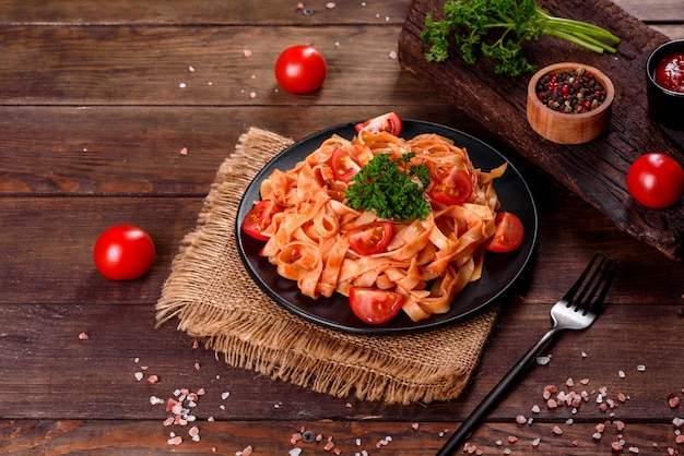 Deliziosa pasta fresca con salsa di pomodoro con spezie ed erbe aromatiche. Cucina mediterranea