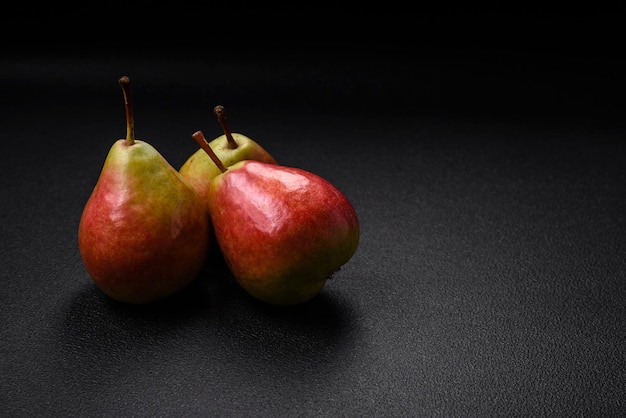 Deliziosa pera verde dolce e succosa con lato rosso su uno sfondo di cemento a consistenza scura