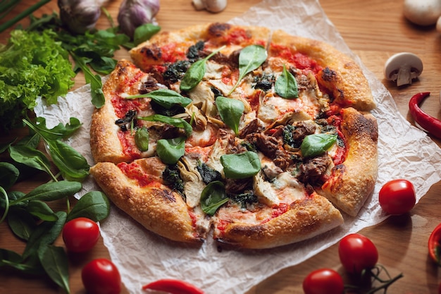 Deliziosa pizza con carciofi e tonno servita su un tavolo di legno