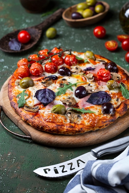 Deliziosa pizza fresca fatta in casa con prosciutto, funghi e pomodori