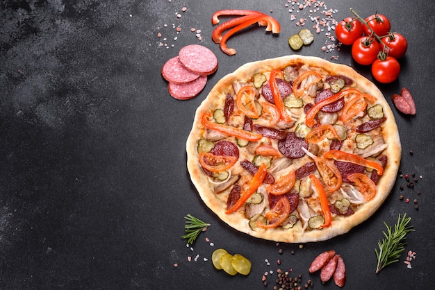 Deliziosa pizza fresca fatta in un forno con focolare con salsiccia, pepe e pomodori. Cucina mediterranea