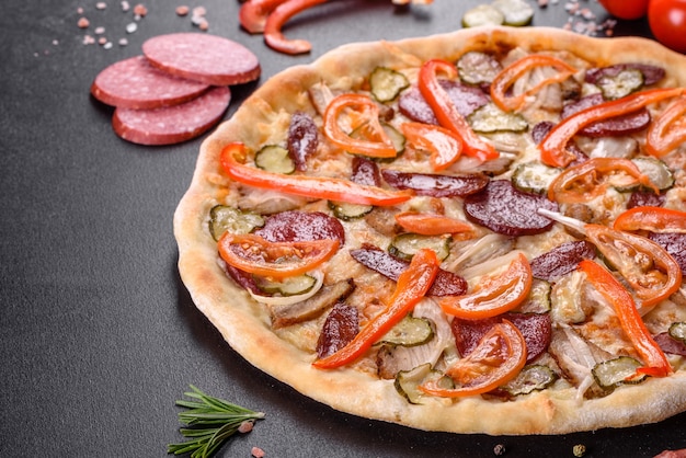 Deliziosa pizza fresca fatta in un forno con focolare con salsiccia, pepe e pomodori. Cucina mediterranea