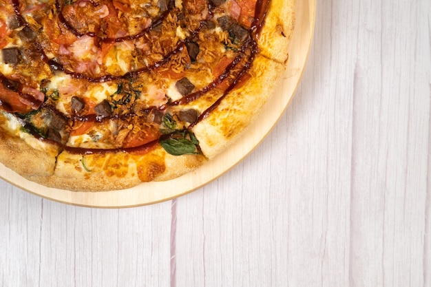 Deliziosa pizza grande con pancetta e spinaci su fondo in legno chiaro