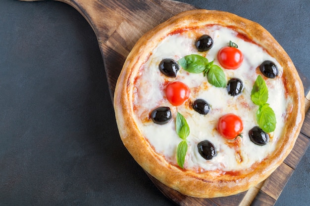 Deliziosa pizza Margherita su un tagliere di legno