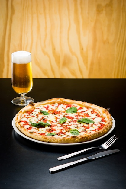 Deliziosa pizza servita con una birra in un ristorante?